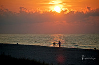 Couple walking on beach at sunrise